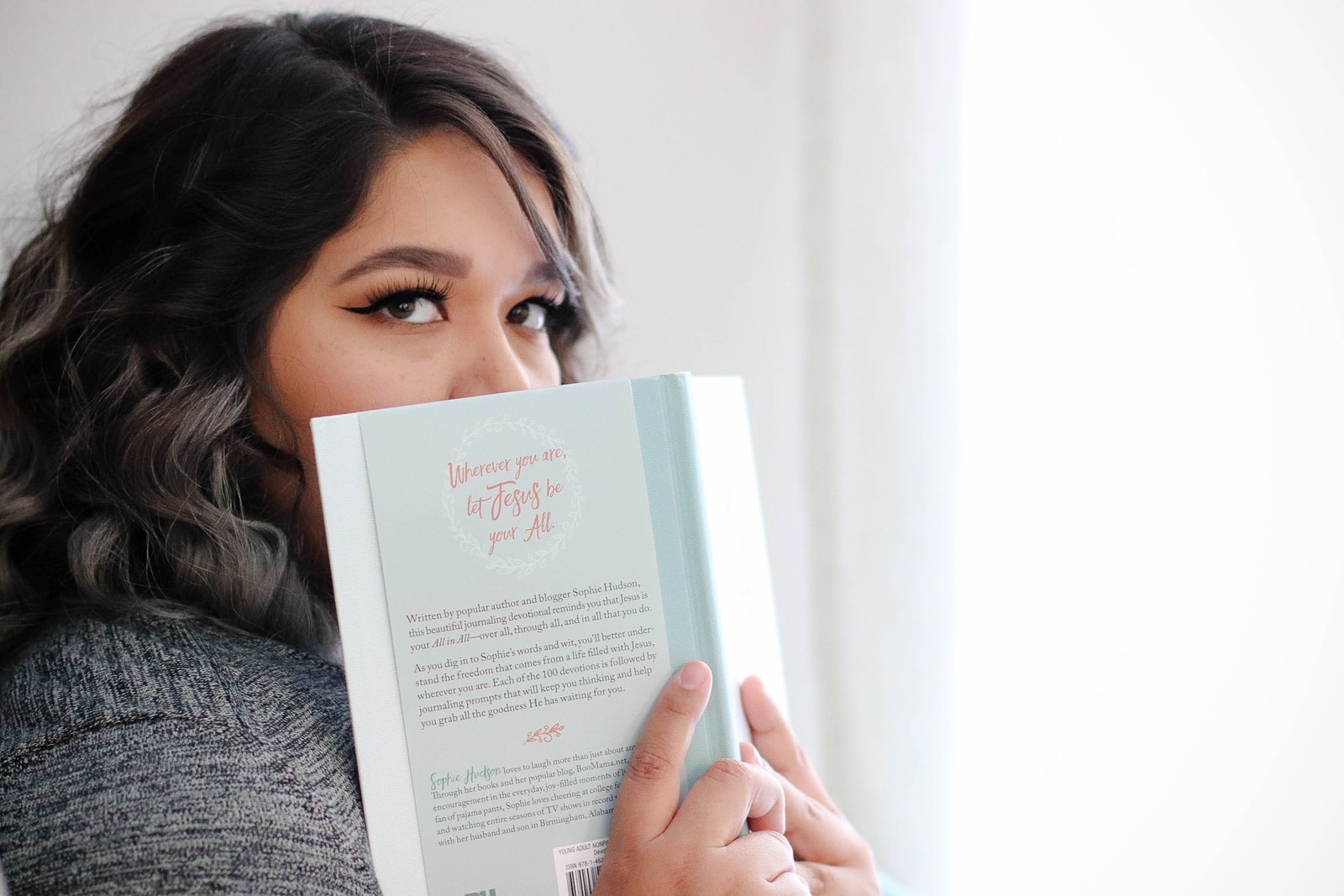 woman covering her face with book