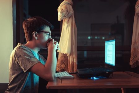 woman in brown shirt sitting in front of laptop computer